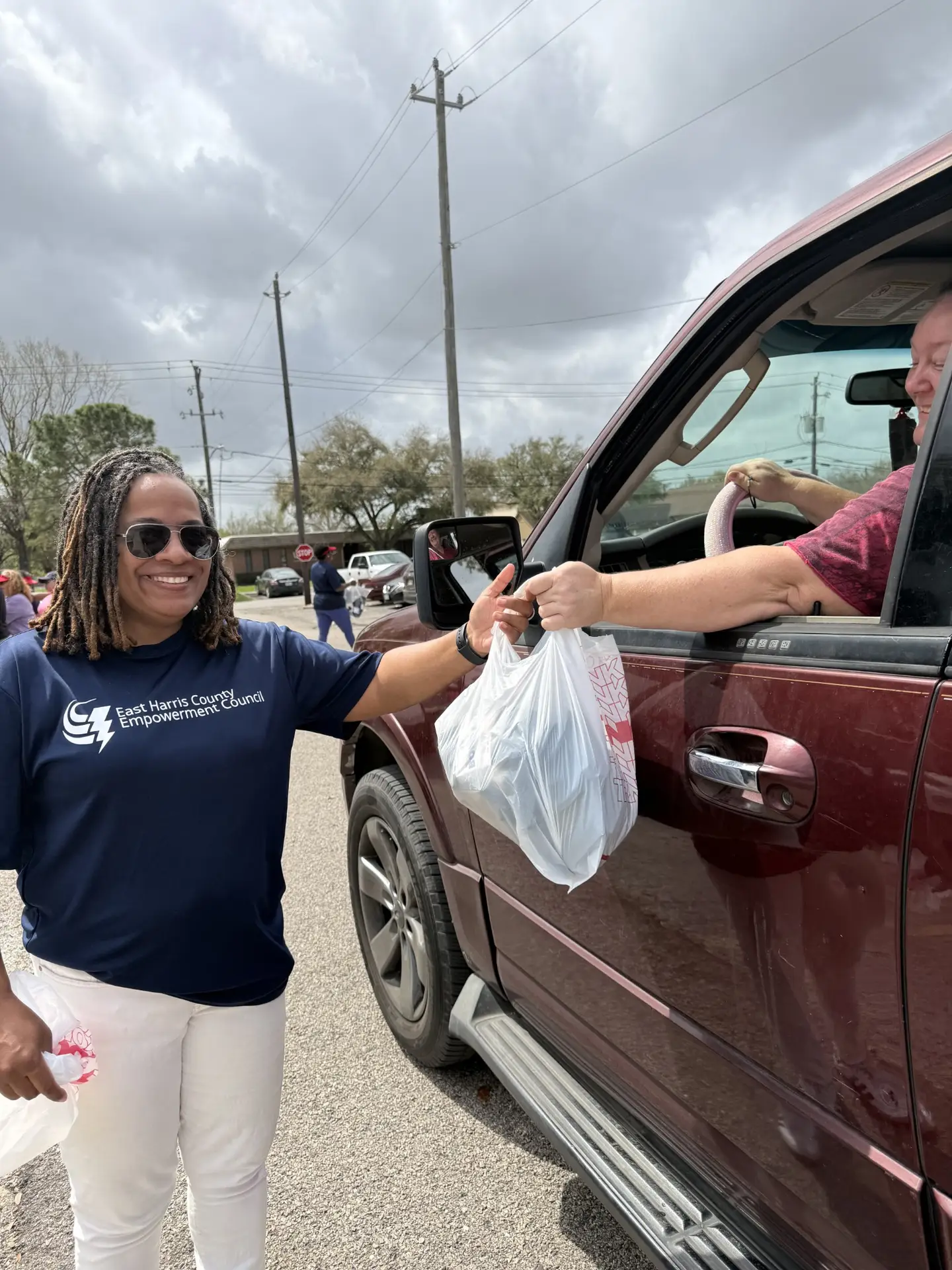 An EHCEC volunteer helping a neighbor at a community distribution.