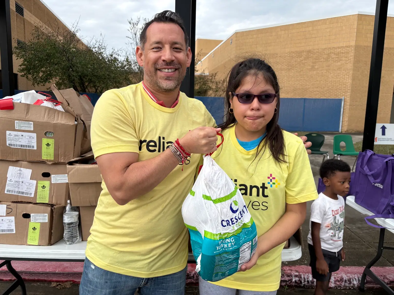 Reliant employee volunteers distributing turkeys at an EHCEC community event